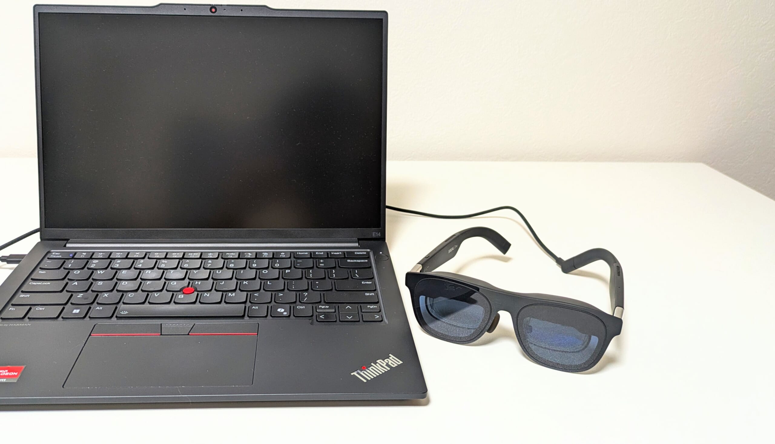 真っ暗な画面のノートパソコンとXREAL Oneをつないでる写真