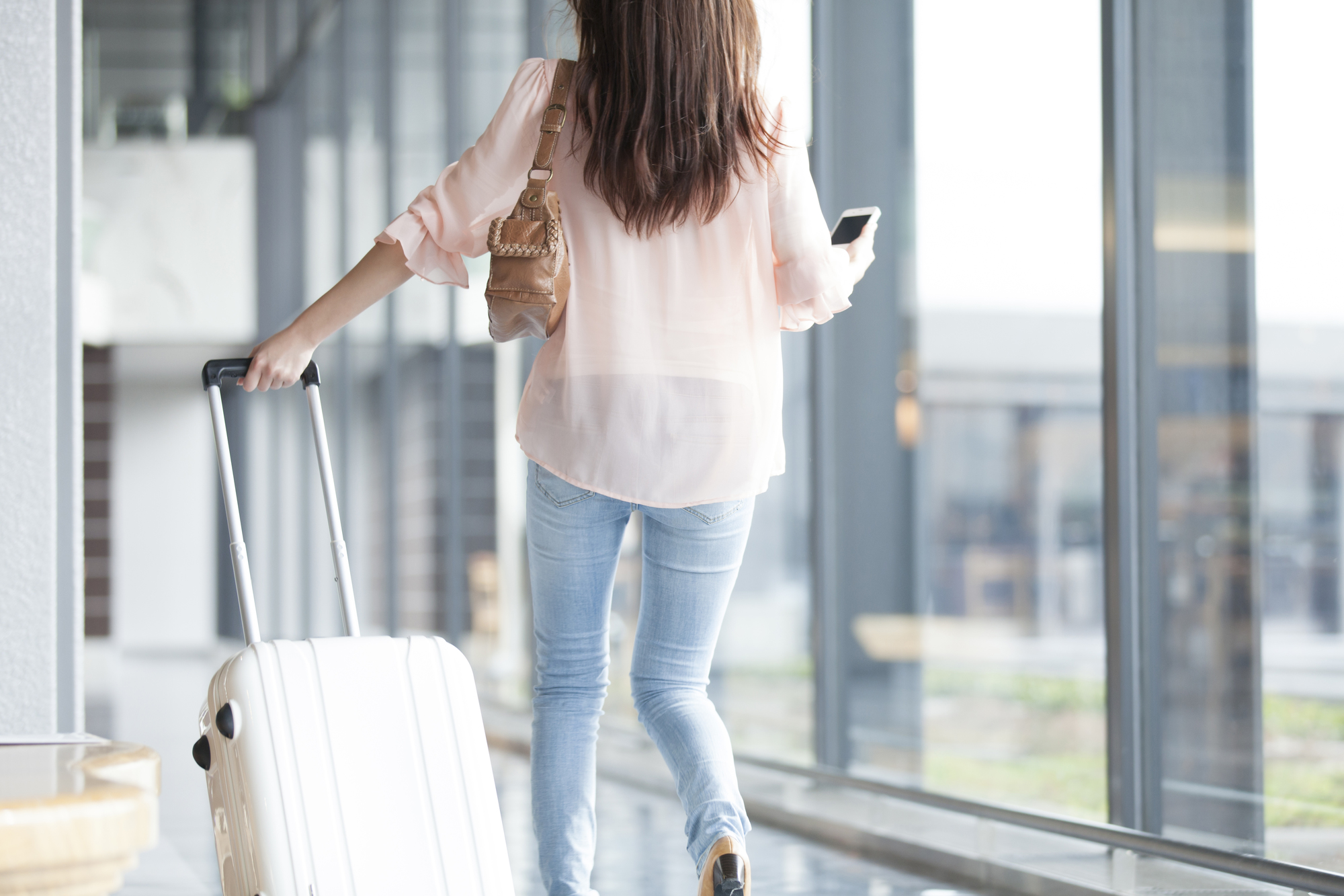 機内持ち込みと預け荷物の違いを解説するイメージ（スーツケース）