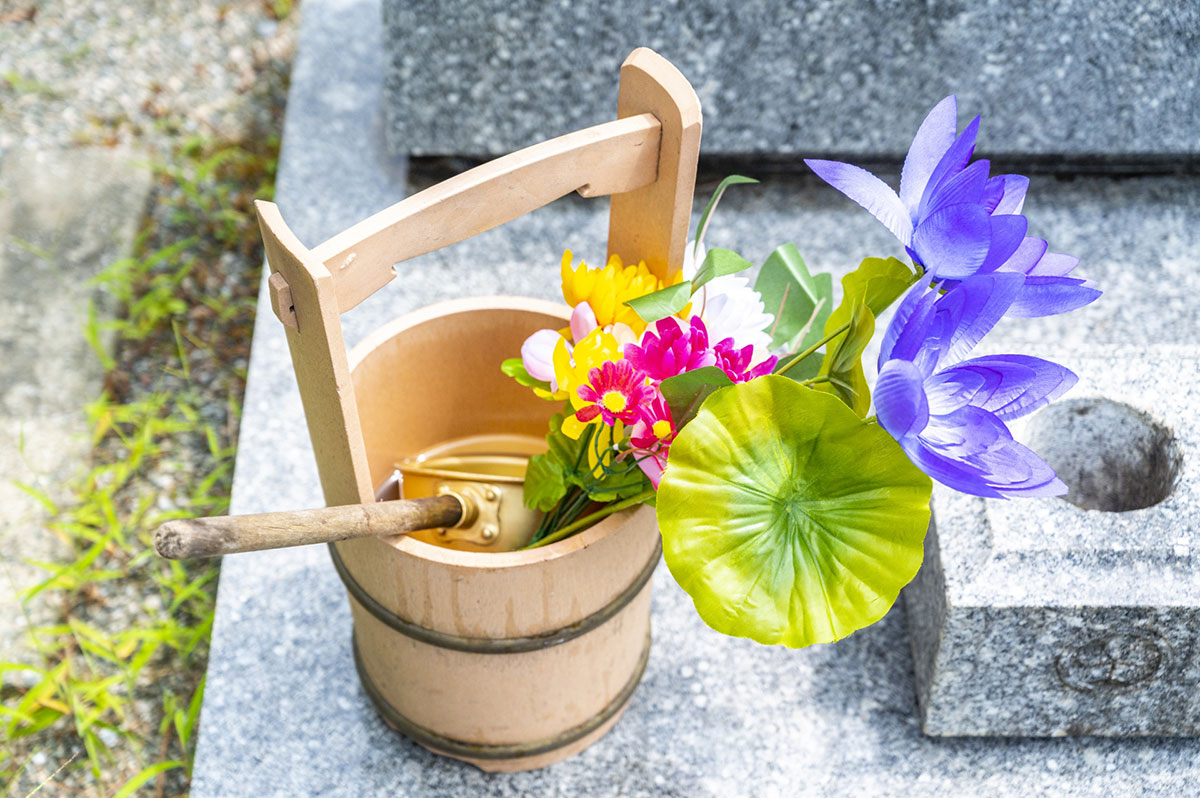 お墓の桶と花のイメージ