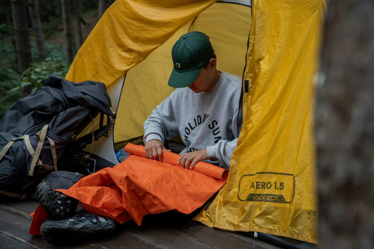 テント・寝袋などキャンプの住まわりの必需品を準備するイメージ