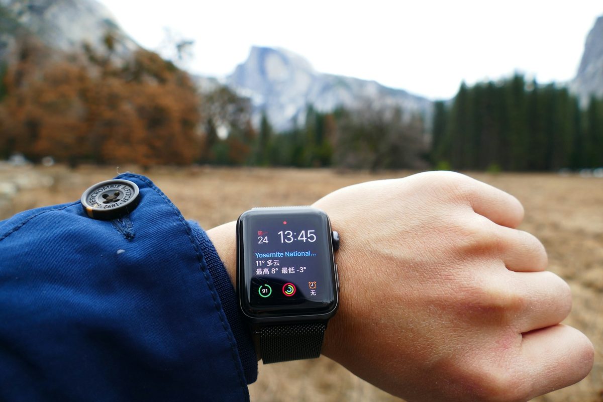 山で手首のApple Watchを確認する様子