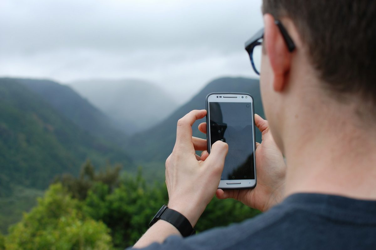 圏外になりやすい山でスマホを確認する登山者